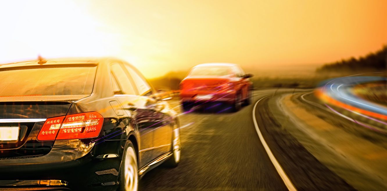 Two cars driving at sunrise