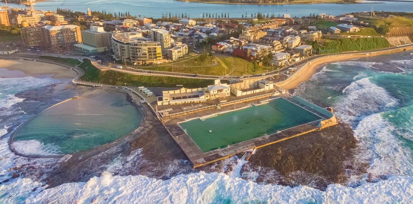 Aerial shot of sun rising over the Newcastle Ocean Baths.