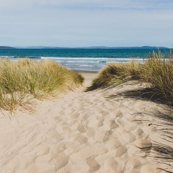 Feel the sand between your toes on Tasmania’s Seven Mile Beach.